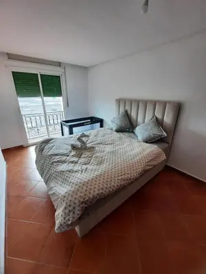a bedroom with a bed and a large window at La Paix Appart in Marrakech