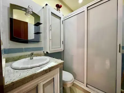 a bathroom with a sink and a toilet and a mirror at appart Confortable BASSATIN GUILIZ in Marrakech