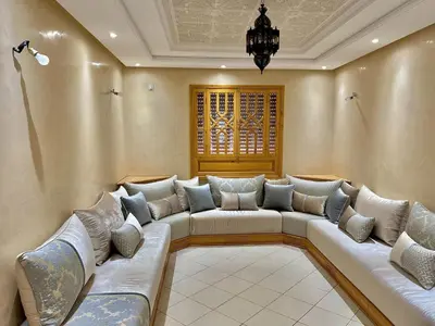 a living room with a couch and a chandelier at Excellent apparentement, in Marrakech