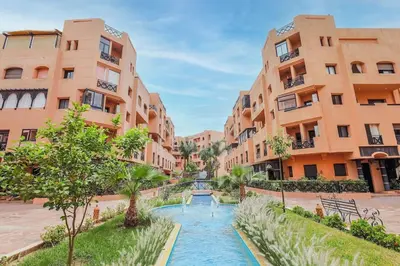 a street in an apartment complex with a river between two buildings at Resort med 24t sikkerhet og basseng - nærme Gueliz in Marrakech