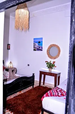 a room with a bed and a table with a mirror at Riad Benrahal in Marrakech
