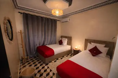 a bedroom with two beds and a chandelier at appartement au cœur du Madina in Marrakech