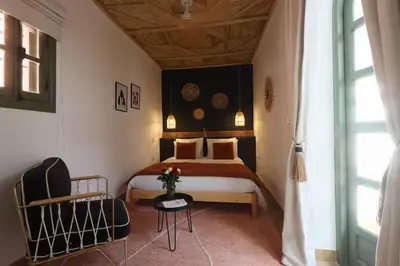 a bedroom with a bed and a chair at Riad Ptit Kech, Bassin terrasse - Petits déjeuners in Marrakech