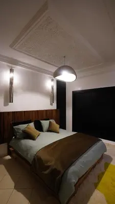 a bedroom with a large bed with a ceiling at Appartement Neuf Carré EDEN in Marrakech
