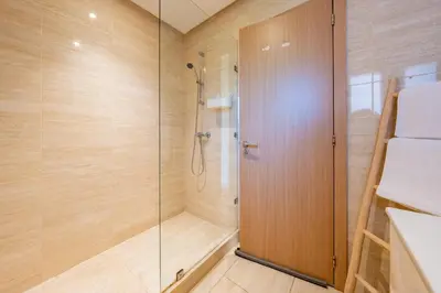 a shower with a glass door in a bathroom at stylish appart with 3Bedrooms in Prestigia in Marrakech