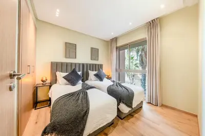 two beds in a bedroom with a window at stylish appart with 3Bedrooms in Prestigia in Marrakech