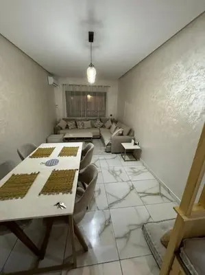 a living room with a table and a couch at Magnifique appartement luxueux à 10mn du centre in Marrakech
