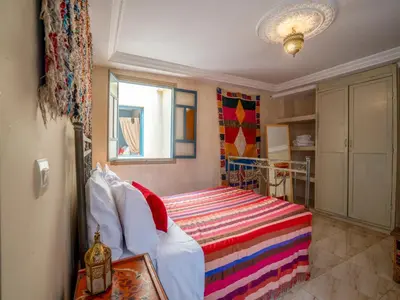 a bedroom with a bed with a colorful blanket at Riad Dar makhzne-location exclusive du Riad entier 4 chambres & terrasse in Marrakech