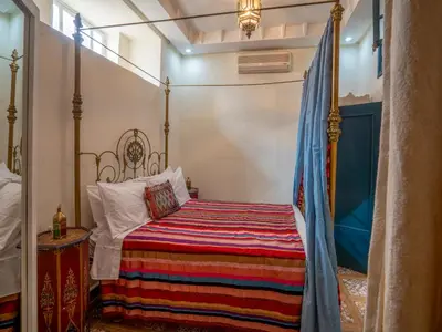 a bedroom with a bed with a colorful blanket at Riad Dar makhzne-location exclusive du Riad entier 4 chambres & terrasse in Marrakech