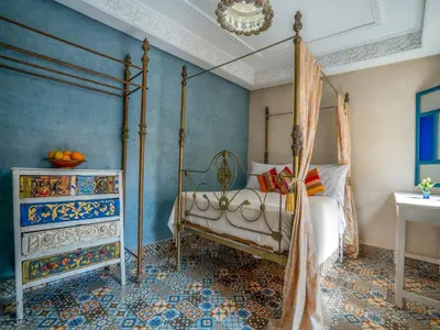 a bedroom with a four poster bed and a chandelier at Riad Dar makhzne-location exclusive du Riad entier 4 chambres & terrasse in Marrakech