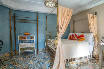 a bedroom with a canopy bed and blue walls at Riad Dar makhzne-location exclusive du Riad entier 4 chambres & terrasse in Marrakech