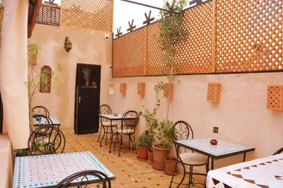 a patio with tables and chairs in a building at Riad marrakesh peace in Marrakech