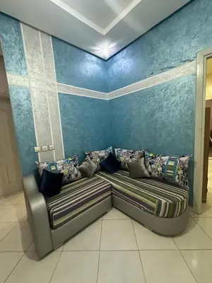 a couch in a room with a blue wall at Spacious Apartment in Menara, 80 m² with View in Marrakech