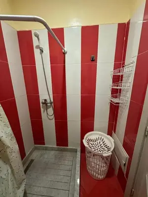 a bathroom with a shower with red and white stripes at Spacious Apartment in Menara, 80 m² with View in Marrakech