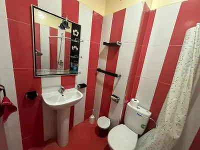a red and white bathroom with a sink and a toilet at Spacious Apartment in Menara, 80 m² with View in Marrakech