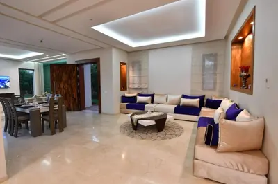 a living room with a couch and a table at villa noria golf 4 chambres centre ville in Marrakech