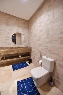 a bathroom with a white toilet and a mirror at villa noria golf 4 chambres centre ville in Marrakech