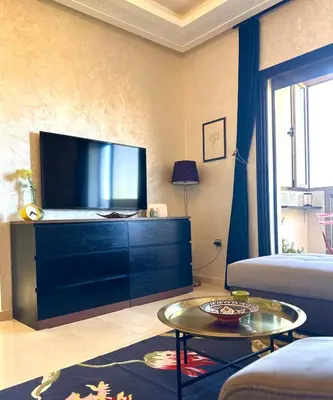 a living room with a flat screen tv on a dresser at Hosted by Zakia in Marrakech