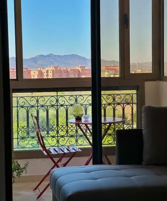 a room with a table and a balcony with a view at Hosted by Zakia in Marrakech
