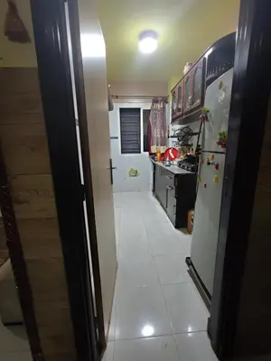 a kitchen with a refrigerator and a white tile floor at zone 44 Massira 3 in Marrakech