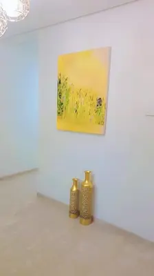 two small vases sitting on a white wall with a painting at Appartement familial de luxe in Marrakech