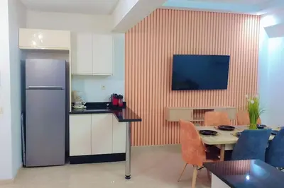 a kitchen with a refrigerator and a table with a dining room at Appartement familial de luxe in Marrakech