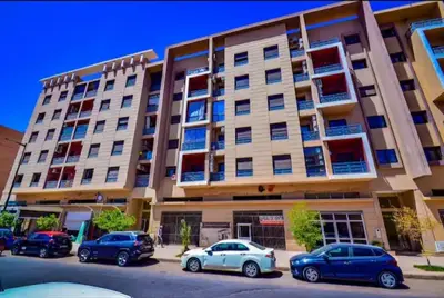 a building with cars parked in front of it at Appartement familial de luxe in Marrakech