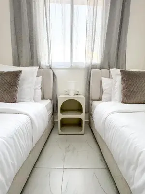 two beds in a room with a window at Lyana Home in Marrakech