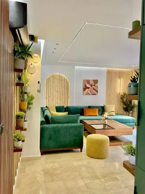 a living room with a green couch and a table at Appartement Marrakech Hivernage N4 RESIDENCE CAPRICE PALACE in Marrakech