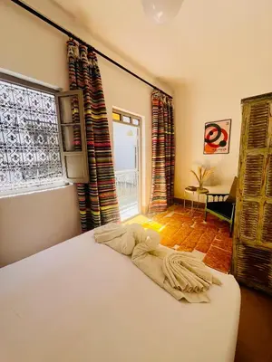 a bedroom with a bed and a window at Votre riad privé en médina avec services inclus in Marrakech