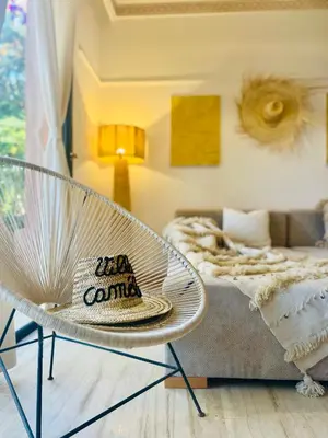 a living room with a chair and a bed at Villa Camélia des 3 Z in Marrakech