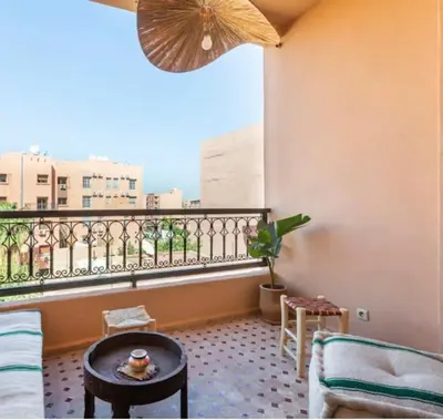 a living room with a view of a balcony at Appart cosy centre-ville piscine et terrasse in Marrakech