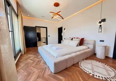 a bedroom with a large bed and a couch at Villa de luxe, Piscine chauffée, Petit Déjeuner, Hammam, Ménage, Proche centre de Marrakech in Marrakech