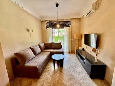a living room with a couch and a tv at Garden Villa-Style Retreat with Patio, BBQ & Pools in Marrakech