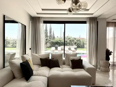 a living room with a white couch and a large window at villa white in Marrakech