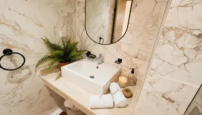a white bathroom with a sink and a mirror at Apartment Coralia - Pool - Terrace in Marrakech