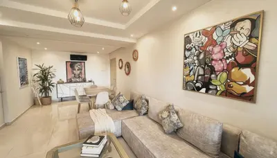 a living room with a couch and a painting on the wall at Apartment Coralia - Pool - Terrace in Marrakech