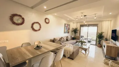 a living room with a couch and a dining room at Apartment Coralia - Pool - Terrace in Marrakech