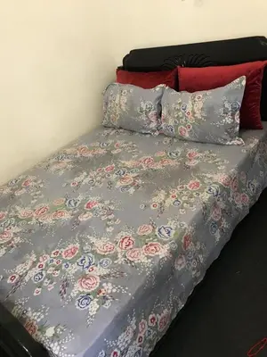 a bed with a gray comforter with flowers on it at DaR CHAMSS in Marrakech