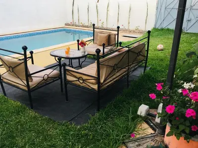 a patio with a table and chairs next to a pool at DaR CHAMSS in Marrakech