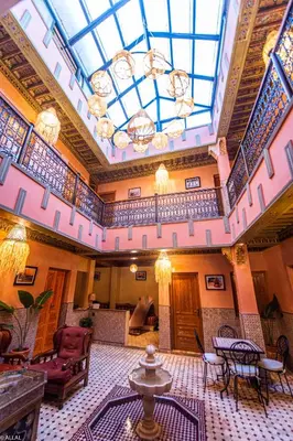 a large lobby with a skylight and tables and chairs at Riad Almonds Marrakech in Marrakech