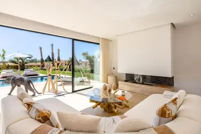 a living room with a white couch and a large window at Dar Al Jenna - Villa de luxe avec piscine privée in Marrakech