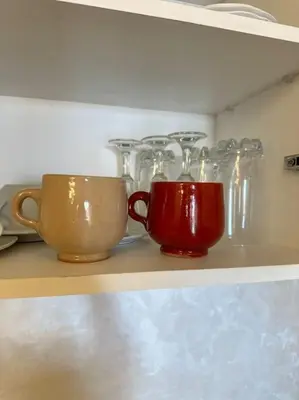 a shelf with two cups and glass containers on it at Appartement Cosy à Marrakech in Marrakech