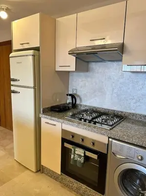 a kitchen with a stove top oven next to a refrigerator at Appartement Cosy à Marrakech in Marrakech