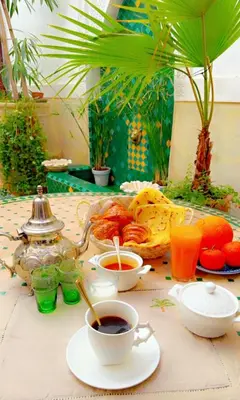 a table with a cup of coffee and a tea pot at Authentique riad Emplacement exceptionnel in Marrakech