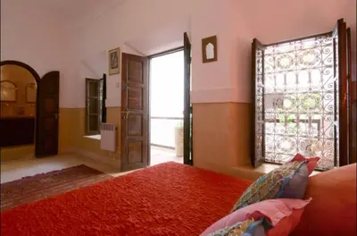a bedroom with a bed and a large window at Authentique riad Emplacement exceptionnel in Marrakech