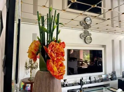 a vase filled with orange flowers on top of a sink at Appart 2 chambres luxe contemporain hivernage in Marrakech
