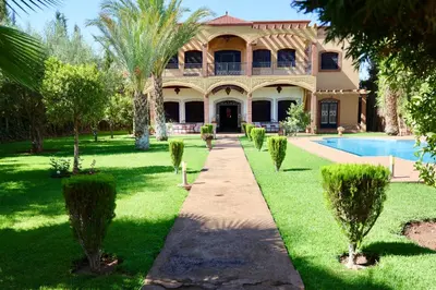 a large house with a swimming pool in the yard at Villa Les Terrasses Des Jardins in Marrakech
