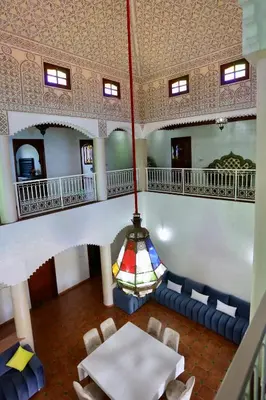a dining room with a table and a chandelier at Villa Les Terrasses Des Jardins in Marrakech