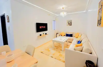 a white living room with a couch and a table at Le Paradise- Cosy, doux et Proche Centre in Marrakech